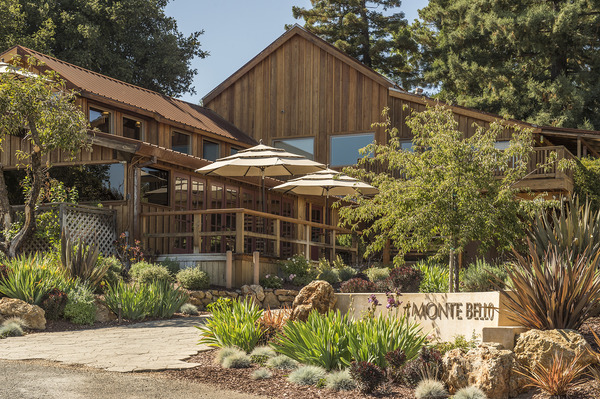 the exterior of the wooden Ridge Monte Bello tasting room with a couple of outdoor umbrellas and landscaped shrubs and trees
